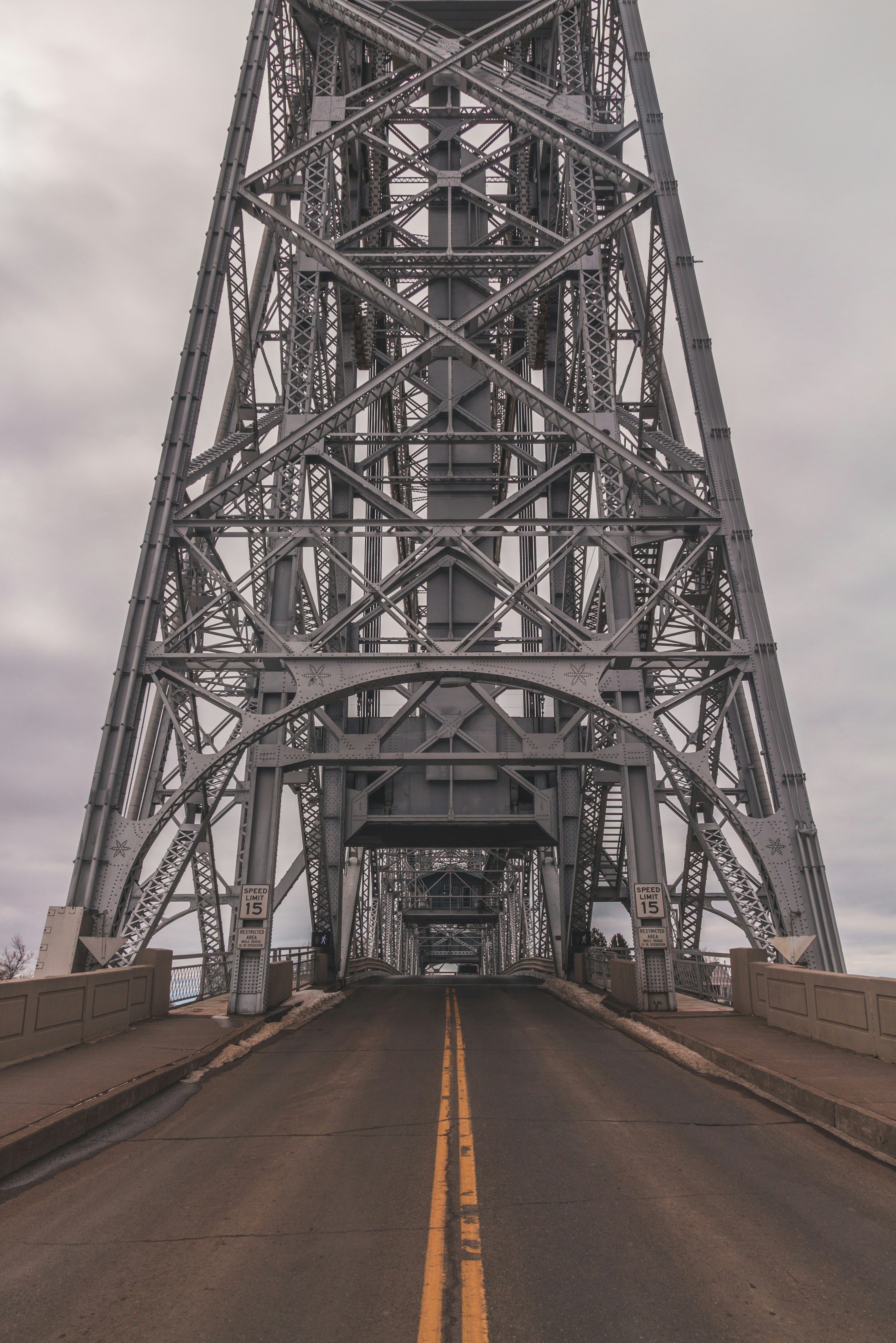 gray steel bridge under gray cloudy sky during daytime